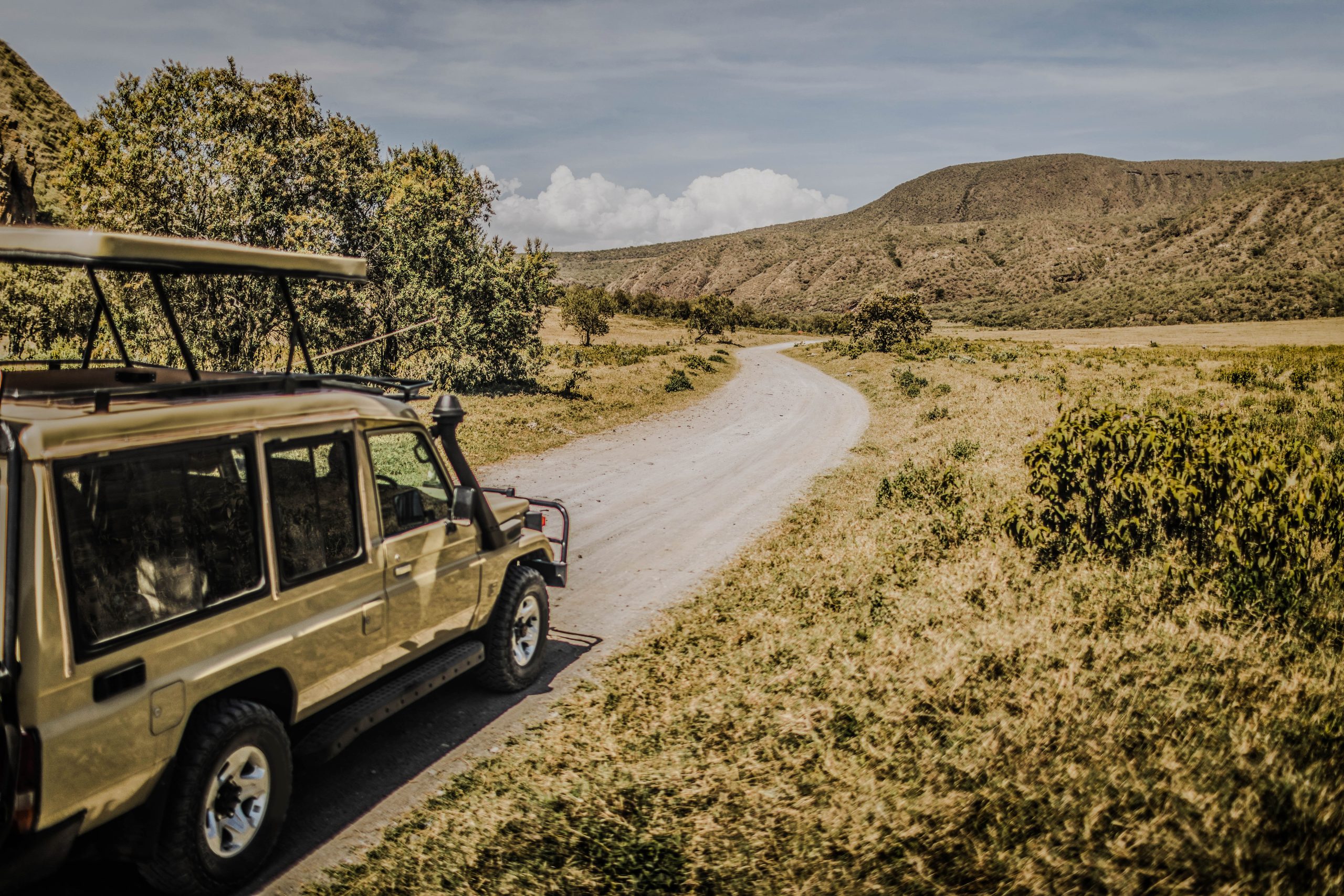 Safari in Hell's Gate national park in Kenya. Off road jeep car, savannah and mountain view. Explore wilderness of Africa.